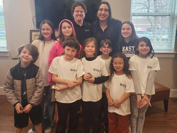 Stephanie and another instructor posing with several young students after a recital.