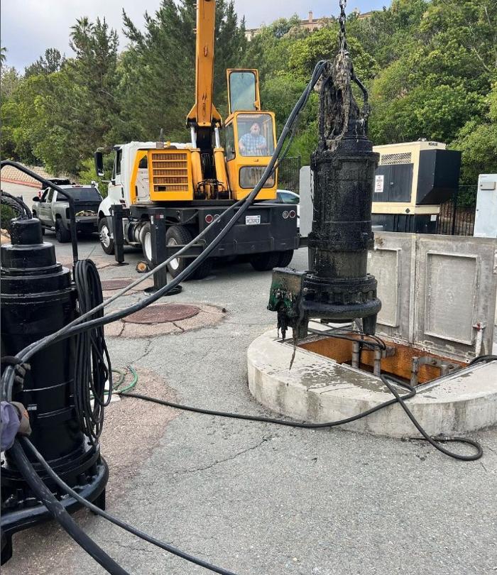 A crane sits next to pumping equipment over a septic system.