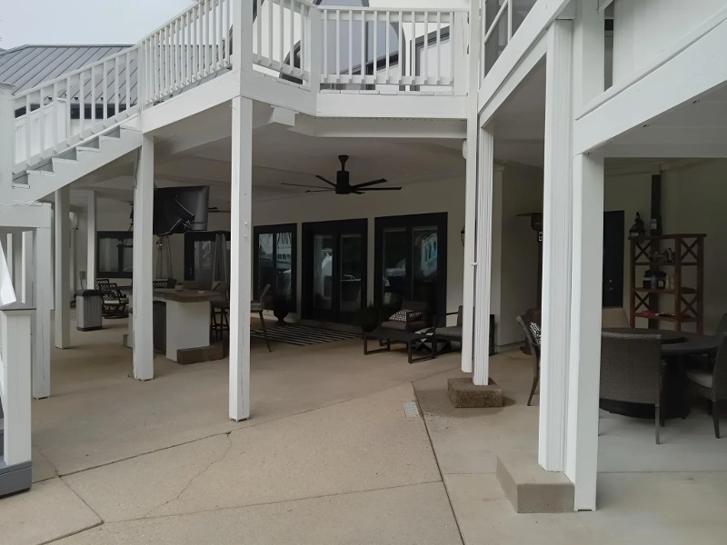 An outdoor two-level patio area with freshly painted woodwork.