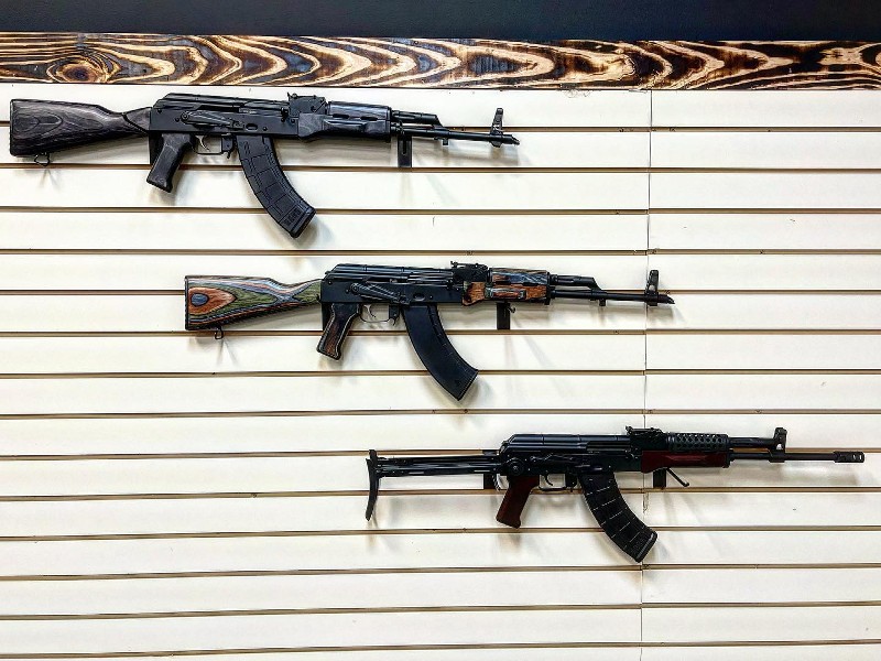 Three rifles hang on a wall.