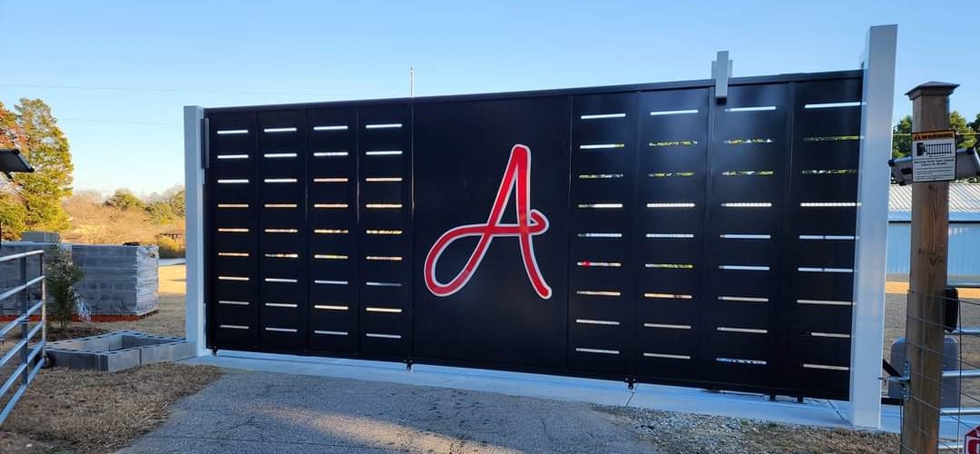 A large black gate with a red script “A” in the center.