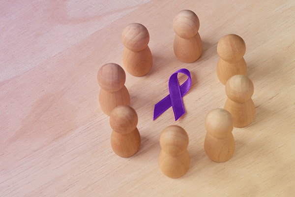 wooden figures in a circle around a purple ribbon