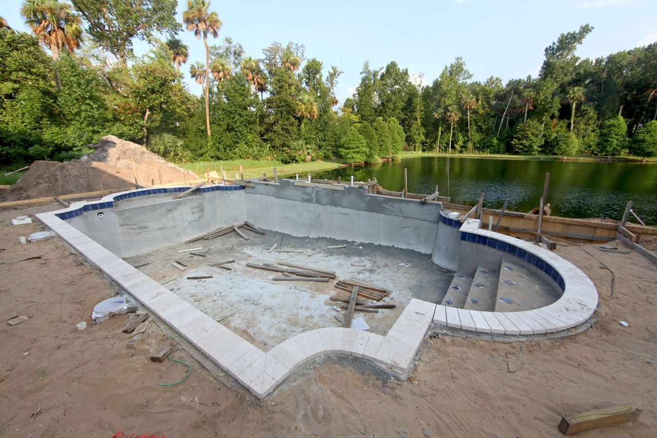 An inground-pool is poured into a dirt space.