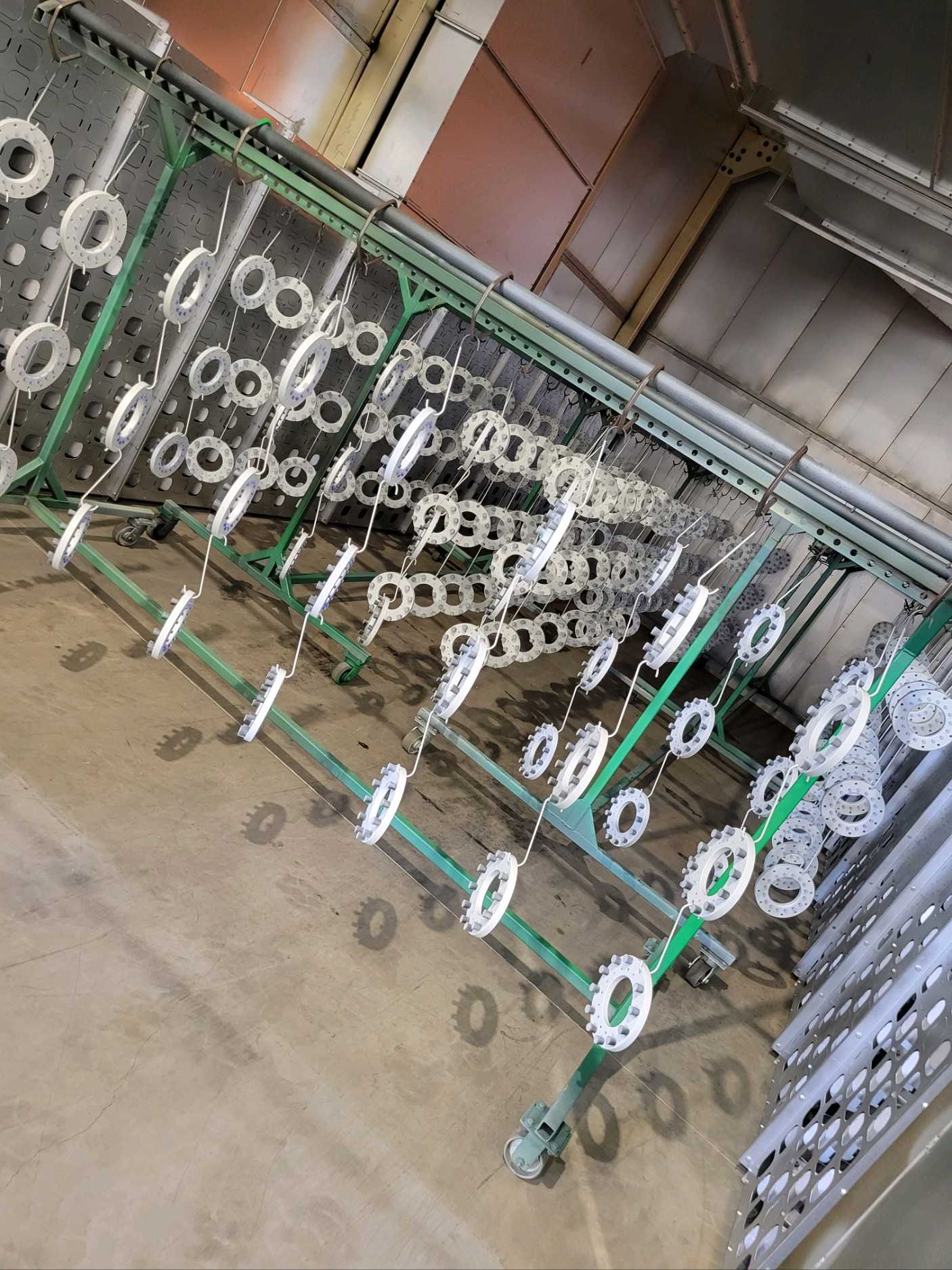 White-coated round wheels hang from hooks