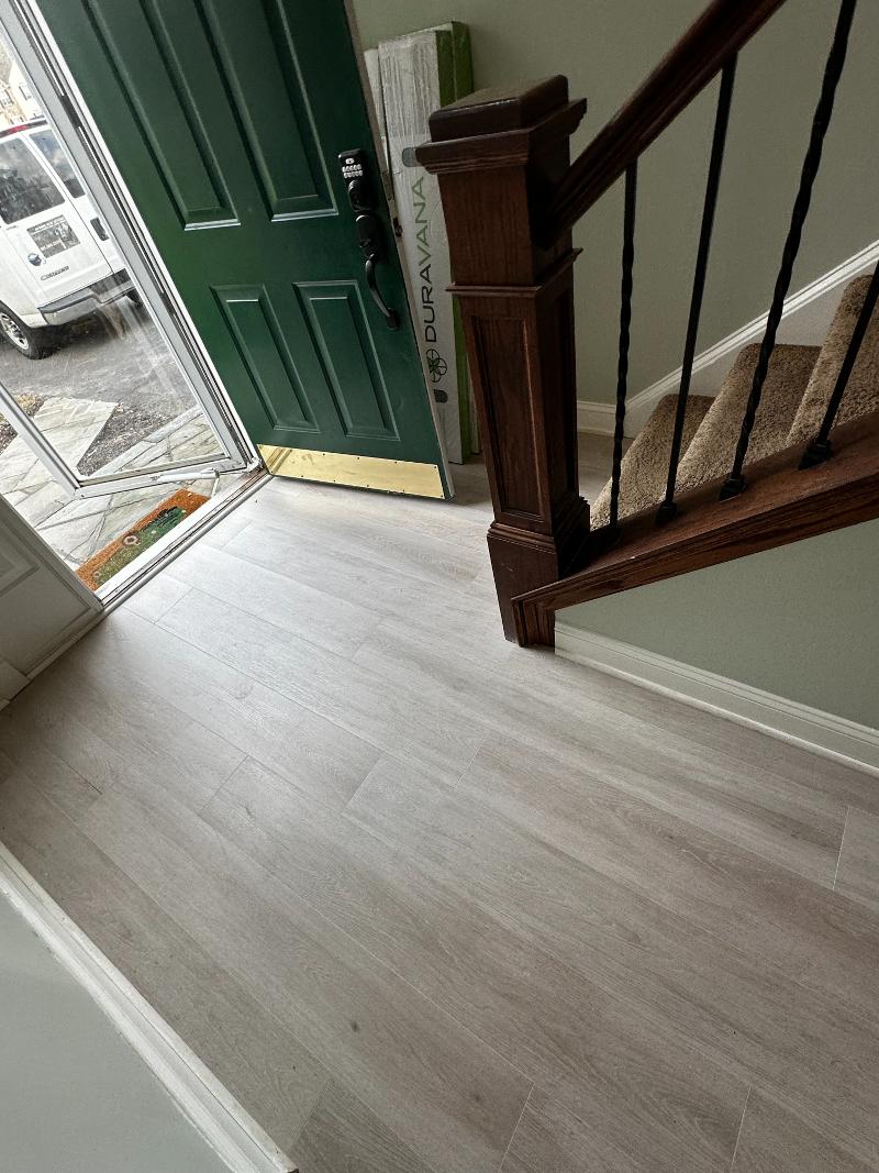 Light grey hardwood flooring next to staircase.