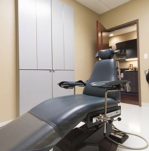 dental exam chair, black, yellow walls with gray cabinets