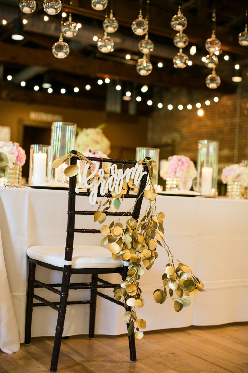 A close-up of a decorative table and chair at a wedding