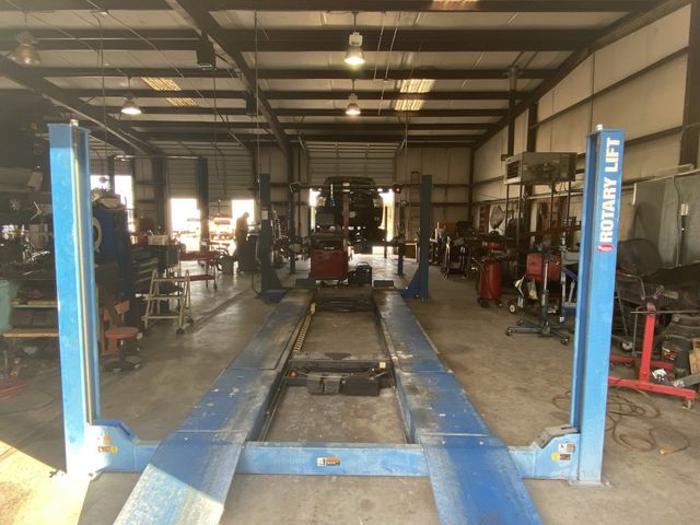 An auto repair service bay with blue lift ramps in an auto repair shop.