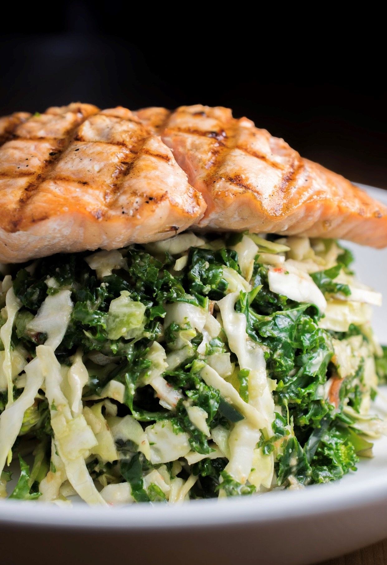 Grilled salmon on a heaping bed of salad.