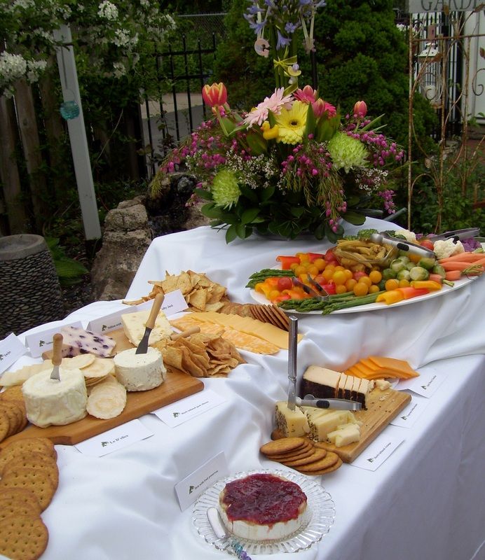 table full of catered fruits, cheese, and crackers