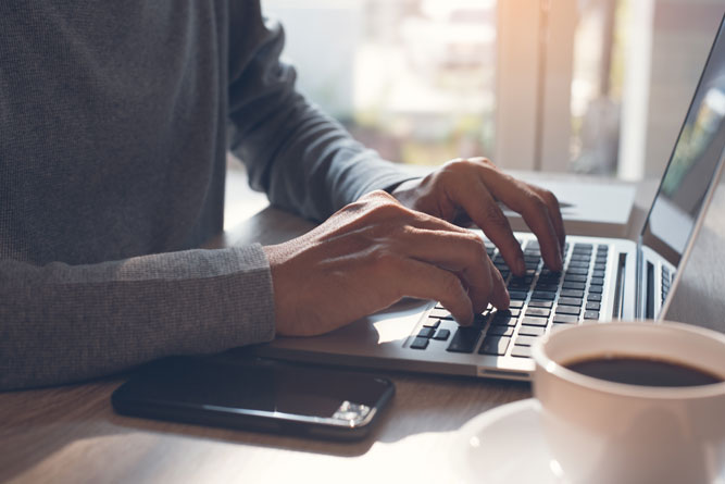 hands typing on laptop computer