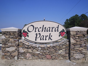 An outdoor sign for Orchard Park.