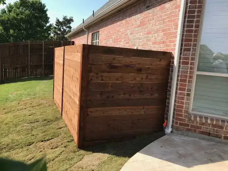 Wooden fence surrounding HVAC system.