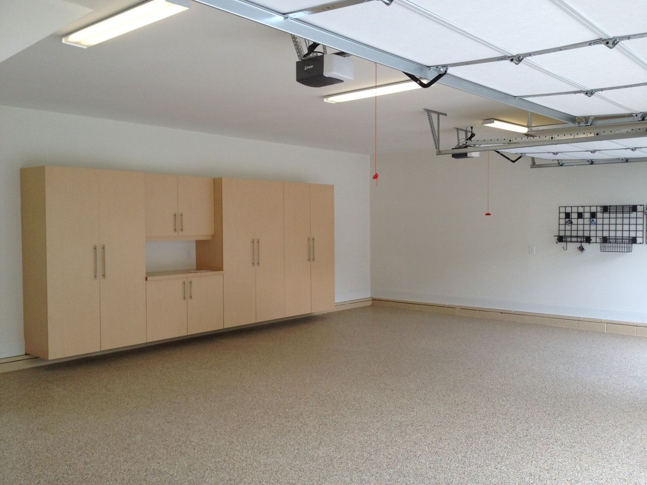 White floor coating and natural wood cabinet solutions in a garage.