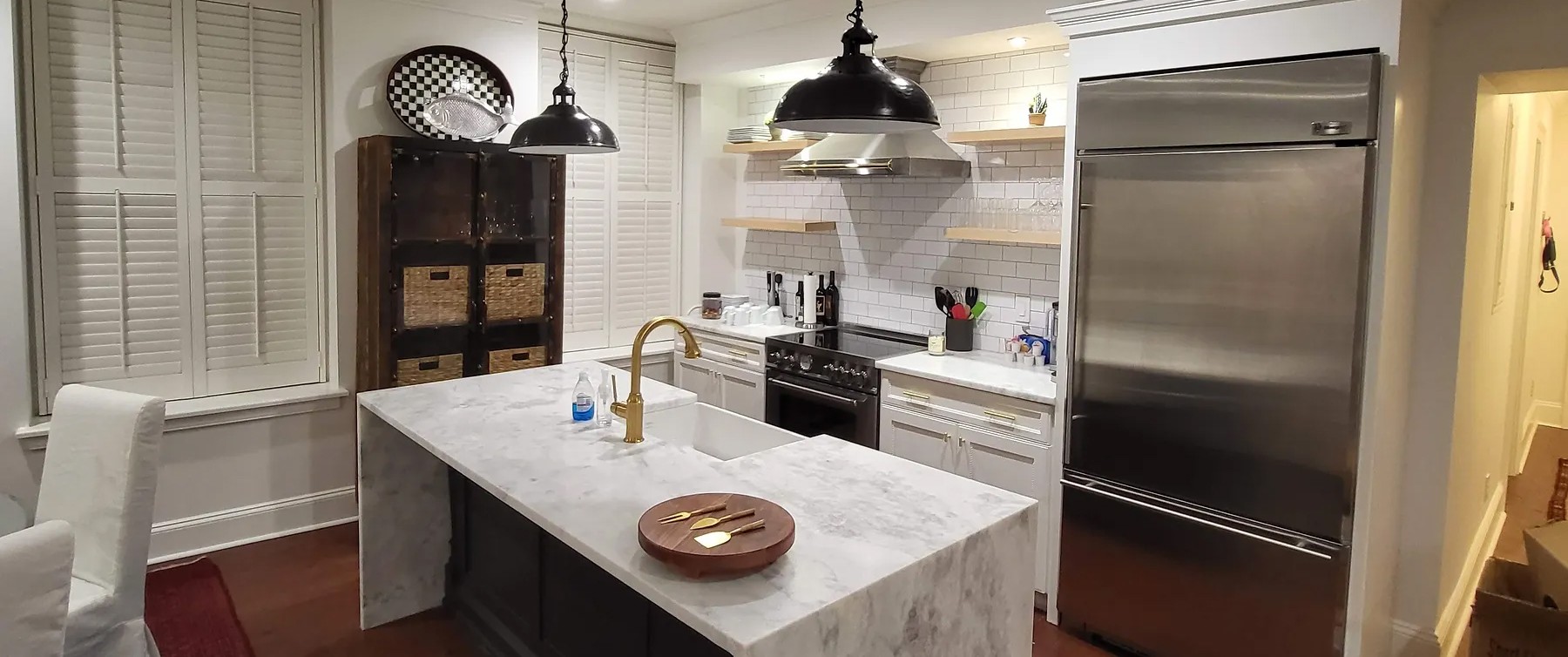 A kitche with a white quartz island and countertops.