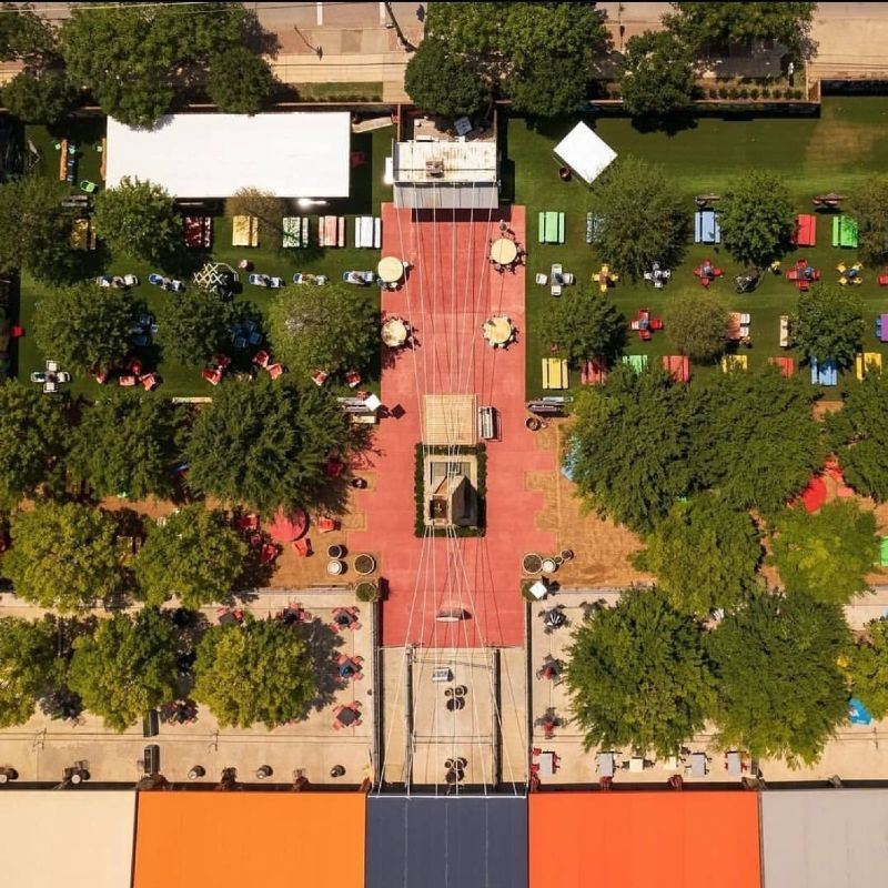 Aerial shot of the vendor market, red brick thoroughfare surrounded by grass and trees