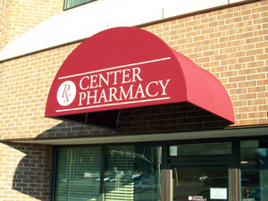 A red circular awning over the business for Center Pharmacy.
