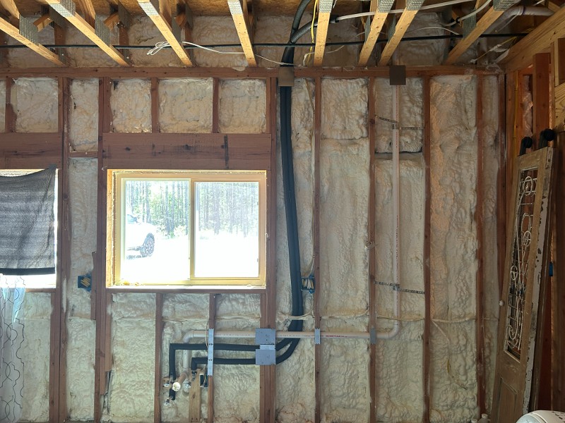 A framed room with insulation blown into the walls.