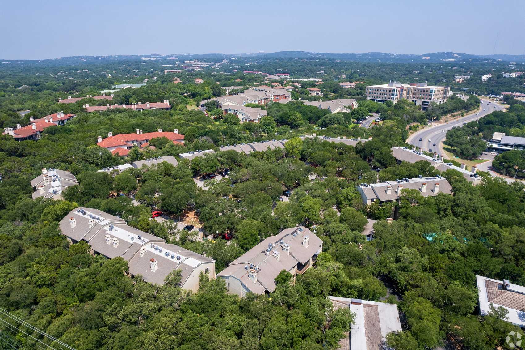 An aerial view of artment buildings surrounded by trees.