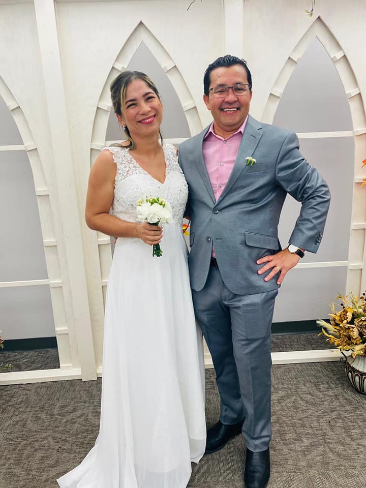 A bride and groom pose for a photo.