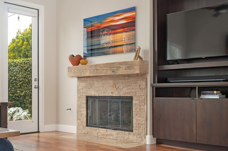 stone fireplace with hardwood floors, entertainment center, flat screen tv