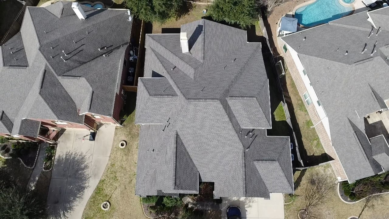 Single story home with multi-layered grey shingle roof.