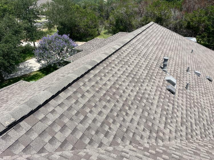 A rooftop view of a tan shingled roof.