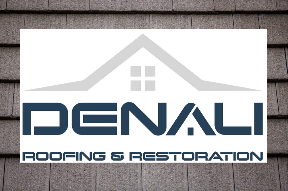 The Denali Roofing & Restoration team poses on top of their roof for a photo.