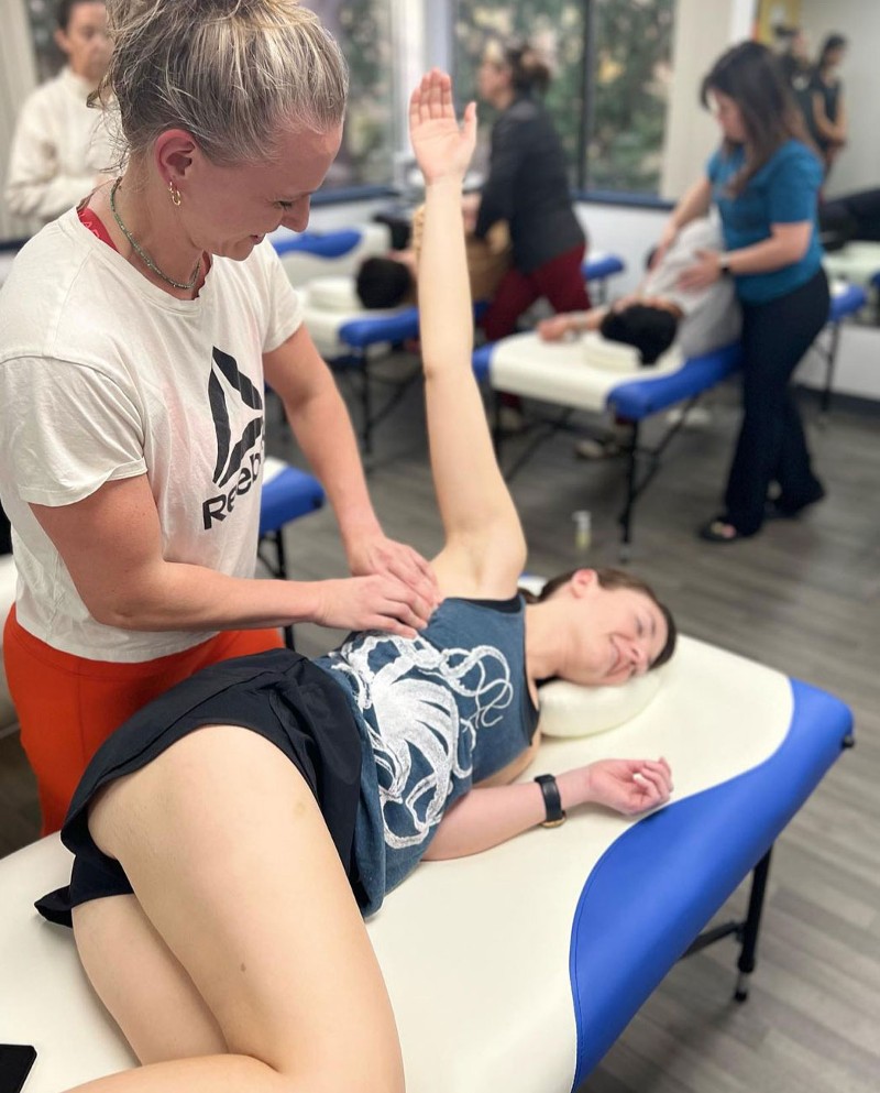 Christa massages the lats of a female athlete.