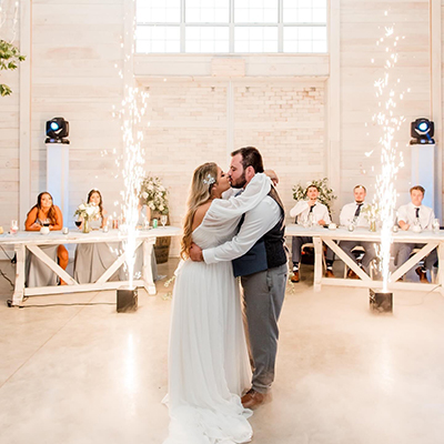 A bride and groom kiss while dancing.