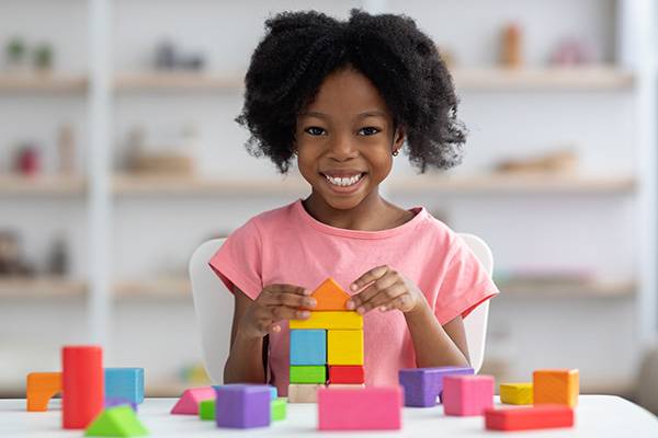 Smiling girl playing with blocks