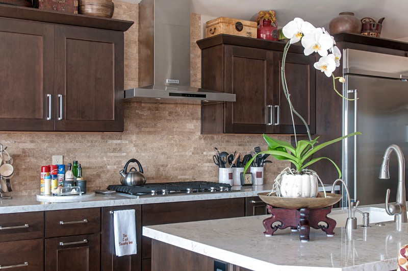 Remodeled kitchen with dark cabinets, light tile backsplash, light granite counter, decorative bar stool style chairs
