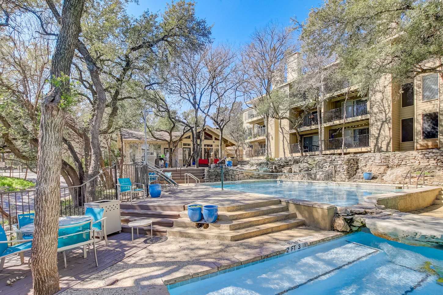 An outdoor pool area in front of apartments.