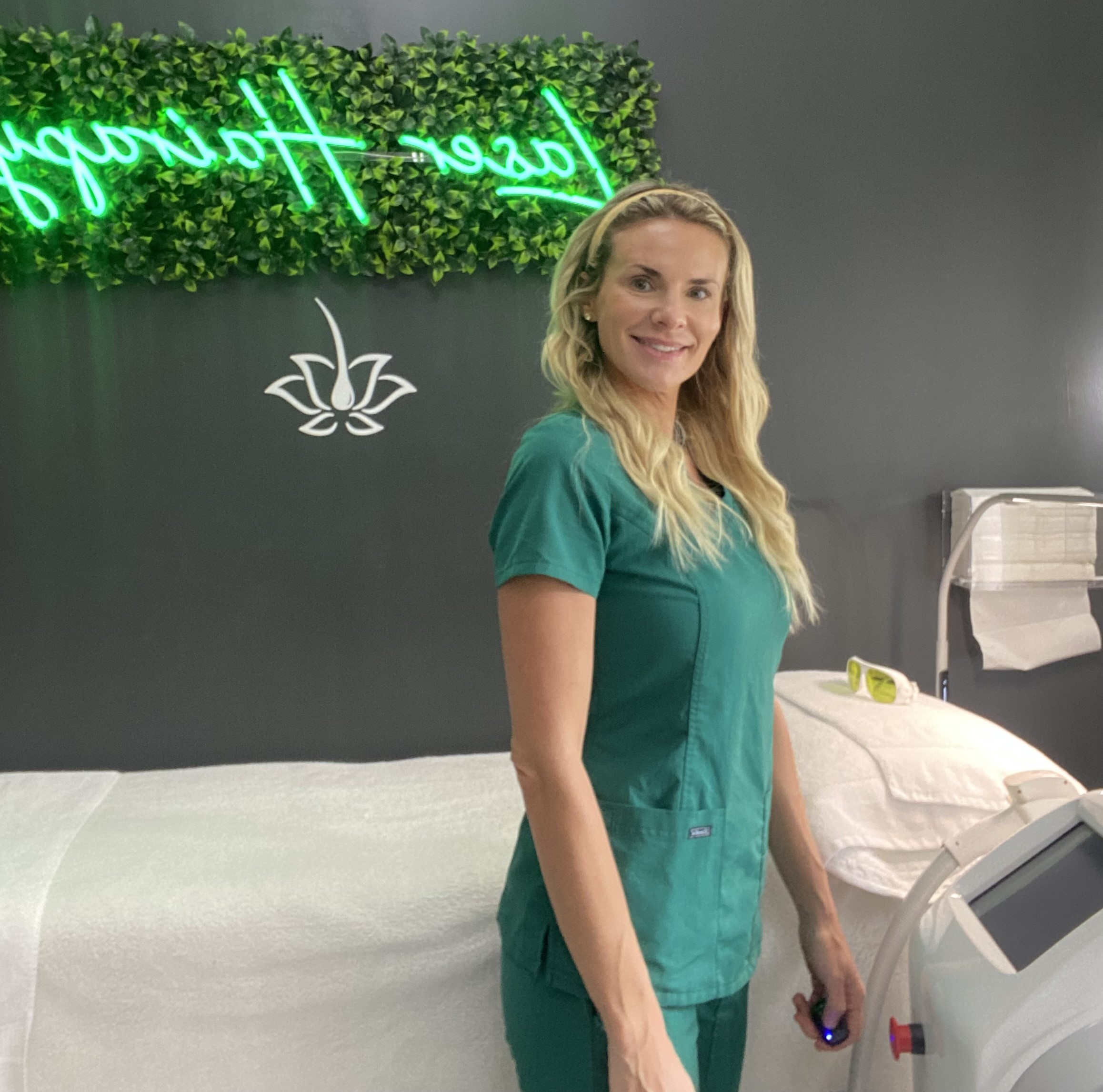 Copeley, founder of Laser Hairapy, poses in front of the laser hair removal treatment area.