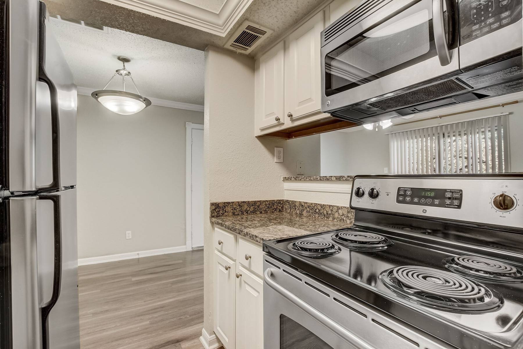 A kitchen with white cabinets and stainless steel appliances.