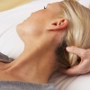 Blonde woman lays on a massage table.