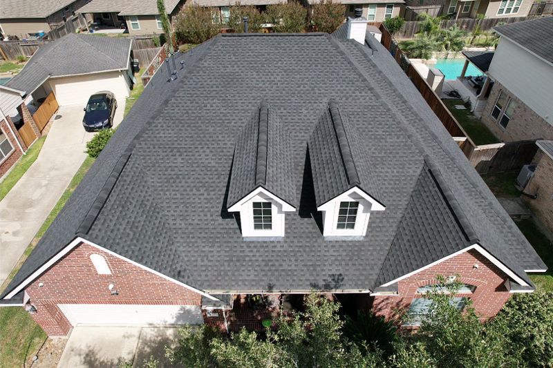 An overhead view of a large home with a gray shingle roof.