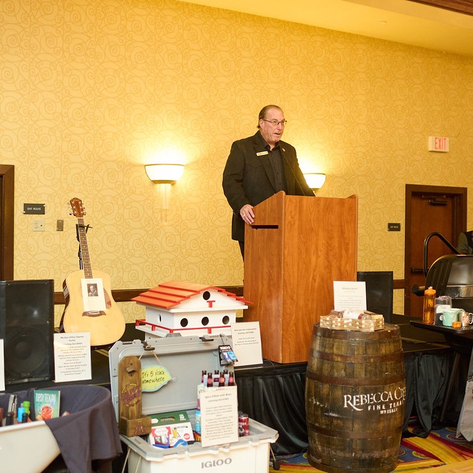 speaker standing behind podium and bidding items