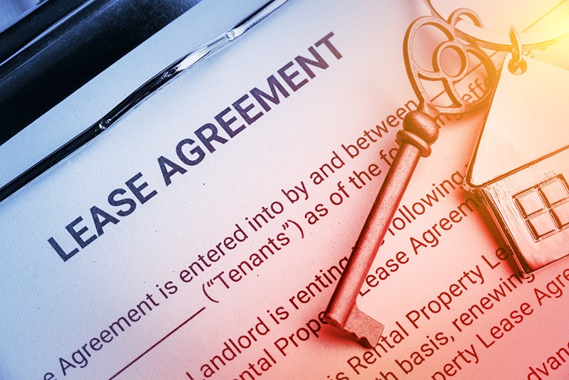 closeup of house key on top of a lease agreement