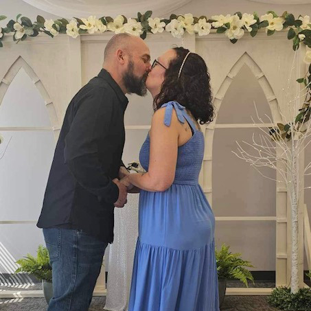 A man and wife kiss at their wedding ceremony.