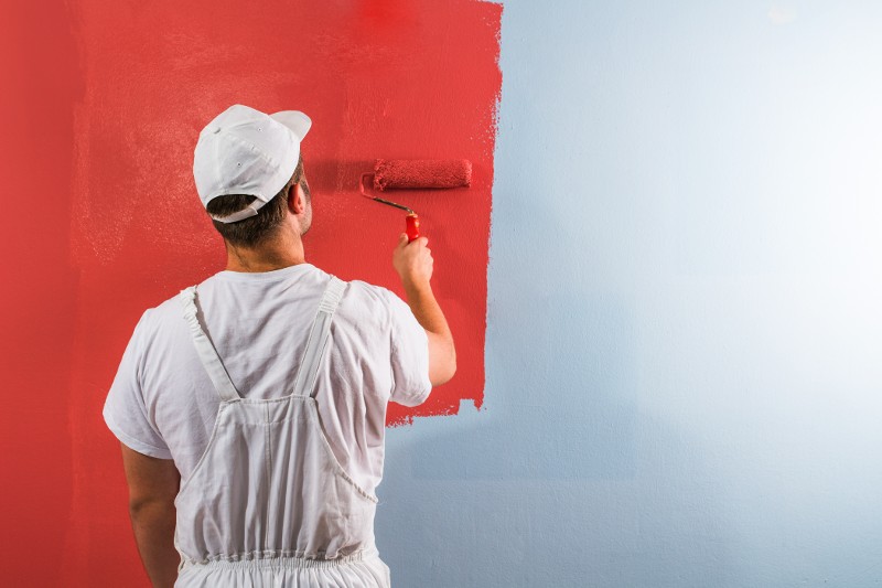 painter painting a wall red