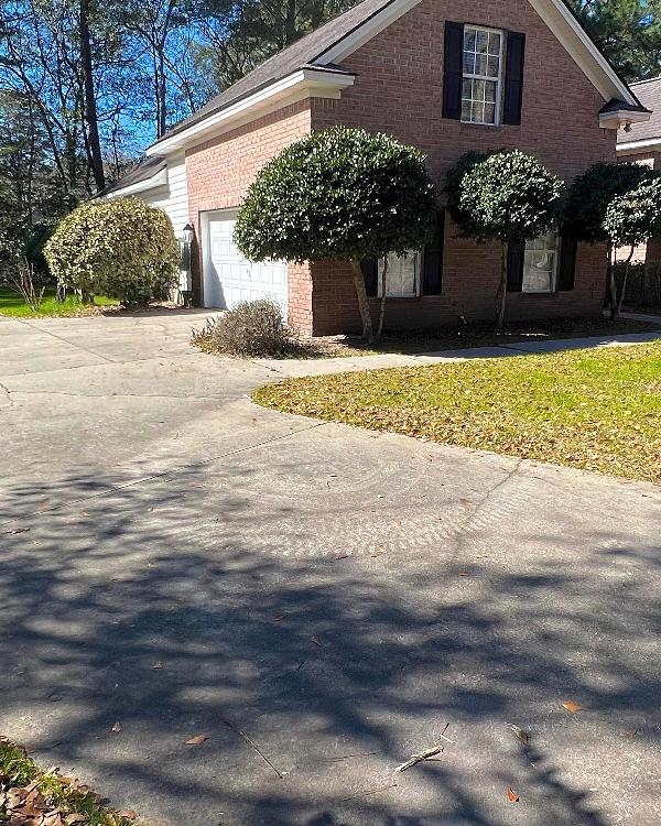 The view of a home's driveway needing pressure washed.