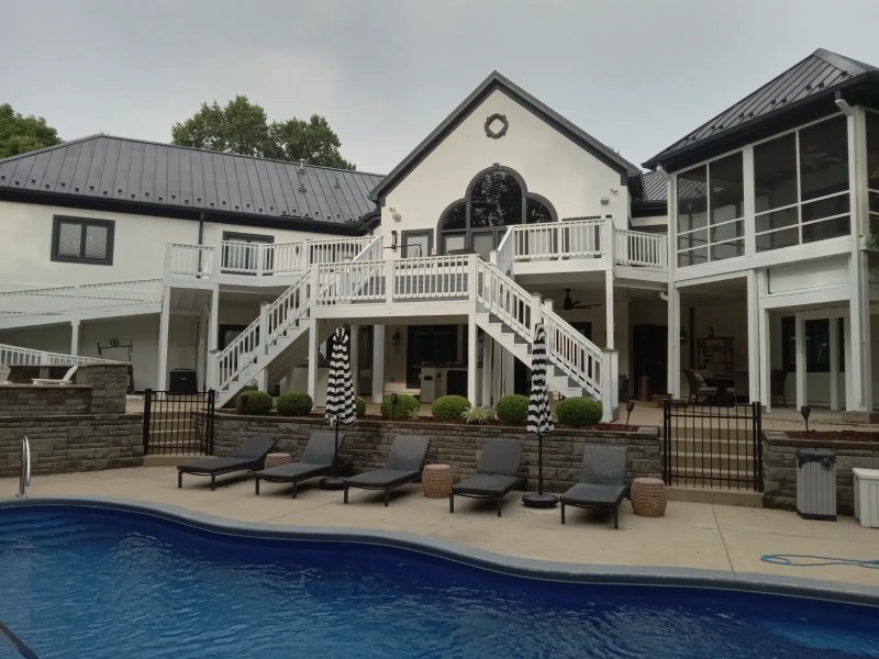 A home with a large, two-level deck with stairway freshly painted.