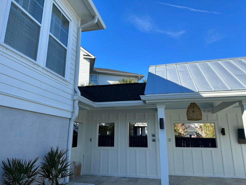 A white gutter system for a house and garage.