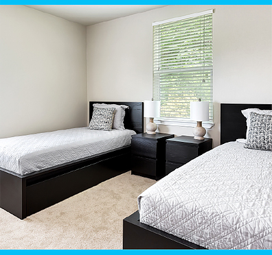 Two twin beds in a bedroom with two nightstands and a window in between the beds.