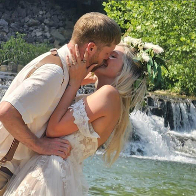 A groom leans over to kiss his bride.