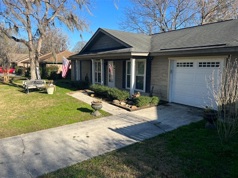 The view of a home's driveway needing pressure washed.