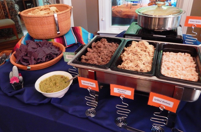 multiple trays of pulled pork and beef on a catering table