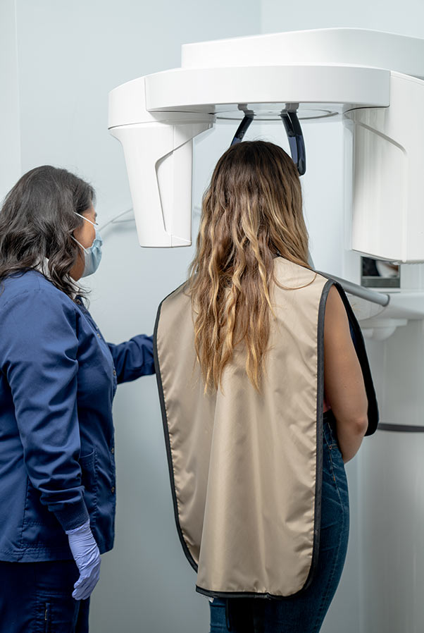 A patient stands in a dental examining machine.