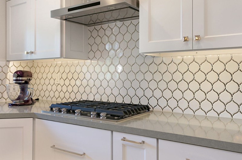 White cabinets with gray granite top, white fish-scale backsplash